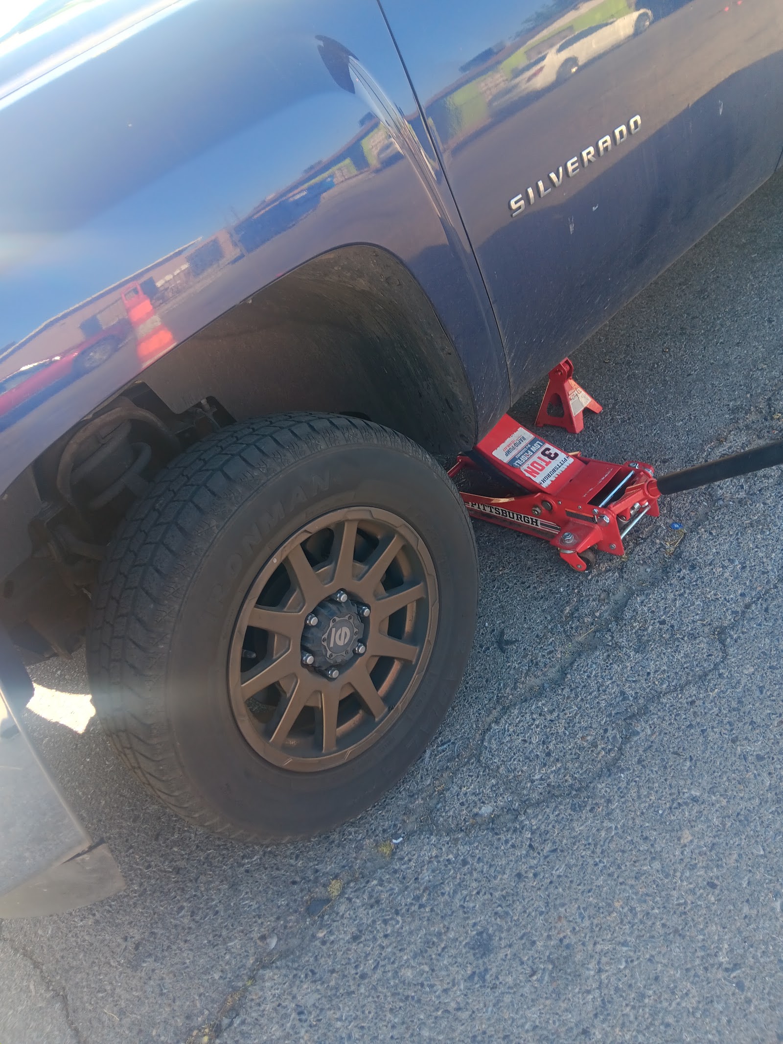 A Chevrolet Silverado raised on a floor jack and jack stand
